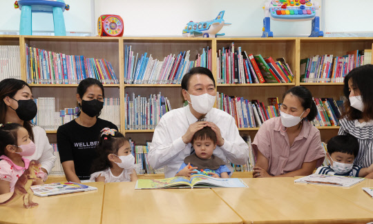 윤석열 대통령이 30일 오전 서울 구로구 가족센터를 방문, 공동육아나눔터에서 공동 육아에 대한 설명을 들은 후 아이들과 함께 그림동화책을 보며 대화하고 있다.<연합뉴스>